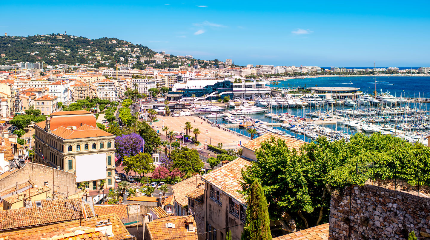 Professionnel consultant une carte interactive des quartiers de Cannes sur tablette pour choisir la localisation stratégique de son hébergement MAPIC